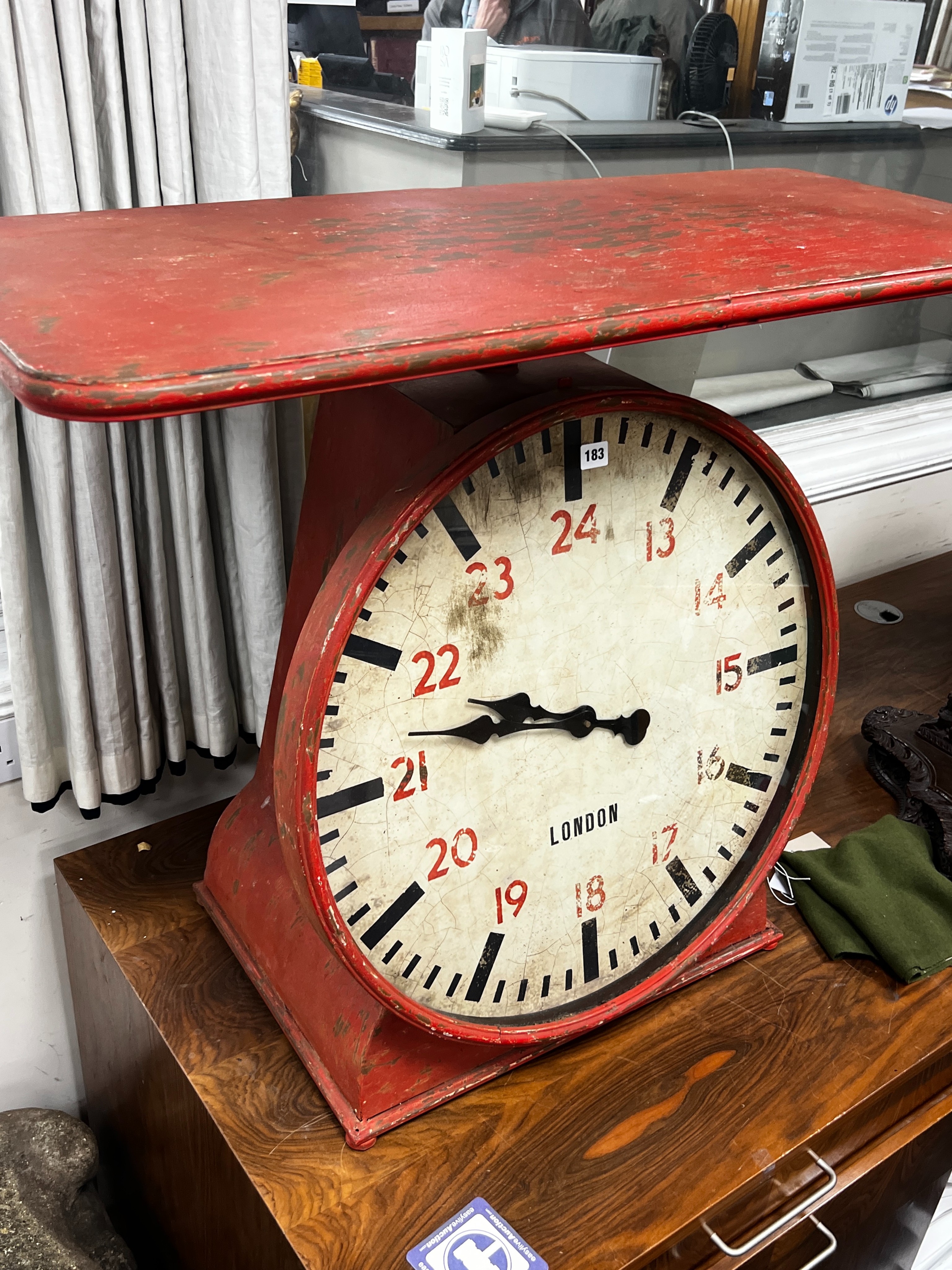 An industrial style painted metal clock console table modelled as a set of scales, width 102cm, depth 46cm, height 80cm.